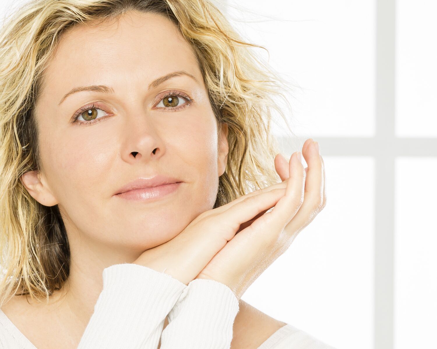 Portrait of a smiling woman resting her chin on her hands